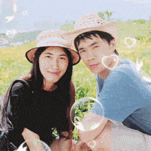 a man and a woman are posing for a picture in a field with soap bubbles around them