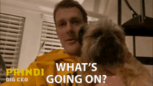 a man holding a small dog with the words what 's going on