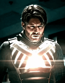 a man in a suit has a light shining on his chest
