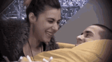 a man and a woman are looking at each other and smiling