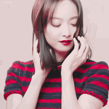 a woman in a red and black striped shirt with chinese writing on the bottom
