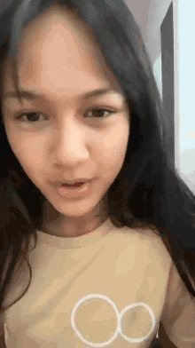 a young woman with long black hair is taking a selfie with her phone .