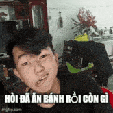 a young man is sitting in a living room with a foreign language caption on his face