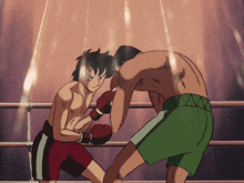two men are boxing in a ring and one has green shorts on