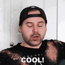 a man wearing a black hat and a black shirt with the word cool on it