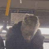 a man sitting on a bus with a sign on the ceiling that says " yoi-jop "
