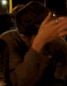 a blurry picture of a person covering their face with their hand