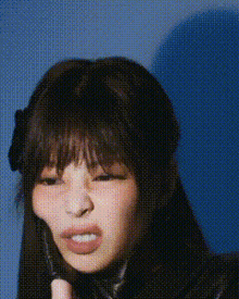 a close up of a woman making a funny face while holding a cell phone .