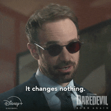 a man wearing sunglasses says it changes nothing on a daredevil poster