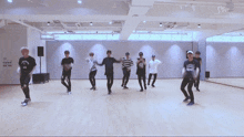 a group of young men are dancing in a dance studio with sm written on the ceiling