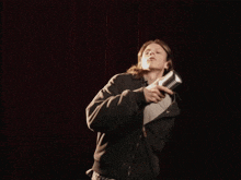 a man in a black hoodie is holding a microphone