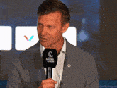 a man in a suit is holding a microphone that says nations league on it