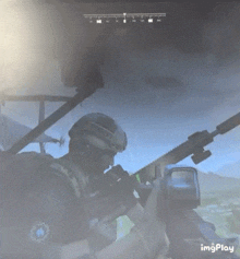 a man in a helmet is holding a rifle in front of a monitor that says imgplay