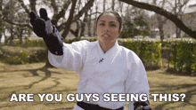 a woman in a white karate uniform is asking if you guys are seeing this