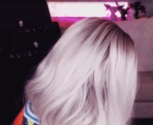 a woman 's hair is visible in front of a sign that says alien