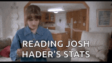 a woman in a denim jacket is reading josh hader 's stats on a tablet