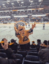 a mascot stands in the stands at a hockey game wearing a yellow shirt that says ' thunder ' on it