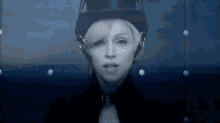 a black and white photo of a woman wearing a top hat .