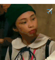 a young girl wearing a green beret and a white shirt