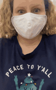 a woman wearing a face mask and a christmas shirt that says peace to y'all