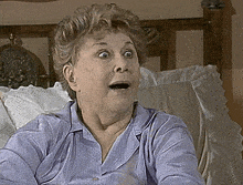 an older woman is sitting on a bed with her mouth open