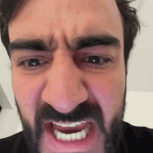 a man with a beard is making a funny face with his mouth wide open