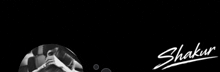 a black and white photo of a person taking a selfie with the name shakur written in white