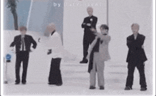 a group of men in suits are standing next to each other on a ice rink .