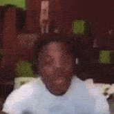 a man is wearing headphones and making a funny face while holding a cell phone .