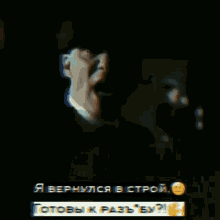 a man in a suit and tie is standing in a dark room with a smiley face .