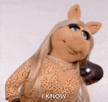miss piggy from the muppet show is talking on a cell phone and smiling .