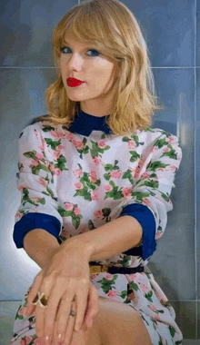 taylor swift is wearing a floral dress and a blue shirt
