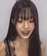 a woman with long black hair and bangs is wearing a black lace bra