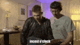 two men are sitting next to each other in a living room and one of them is talking about incest o ' clock .