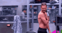 a shirtless man is standing in front of a mirror in a dressing room .