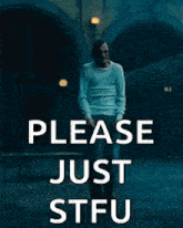 a man in a white shirt is walking in a dark room and says please just stfu