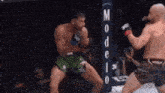 two men are fighting in a boxing ring with a sign in the background .