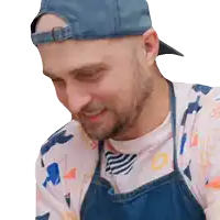 a man wearing an apron and a baseball cap