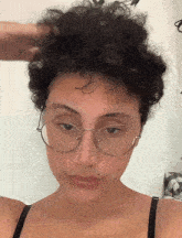 a woman with short curly hair wearing glasses