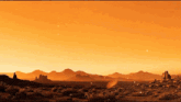 a desert landscape with mountains in the background and a sunset