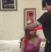 a man is putting a red scarf on a woman in front of a picture of dustin