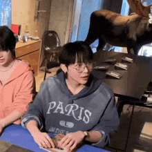 a man wearing a hoodie that says paris on it