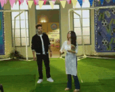 a man and a woman standing in front of a sign that says ' hostel ' on it