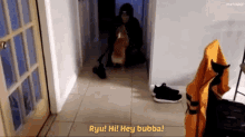 a man sitting on the floor with a dog and says " ryu hi hey bubba "