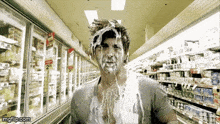 a man is covered in milk in a grocery store aisle