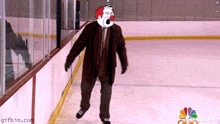 a man wearing a clown mask is walking on a rink