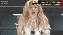 a woman in a white dress with a stardom logo on the bottom right