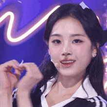 a close up of a woman making a heart with her hands on a stage