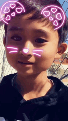 a young boy with hearts on his face and a cat nose
