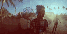 a man in a plaid shirt is standing in front of a large fan